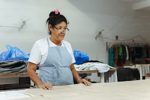 a woman in an apron working on a piece of wood