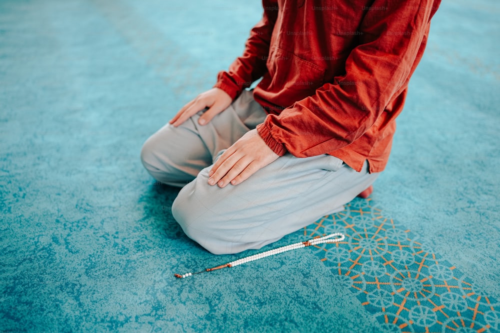 a person sitting on the floor with a crochet hook
