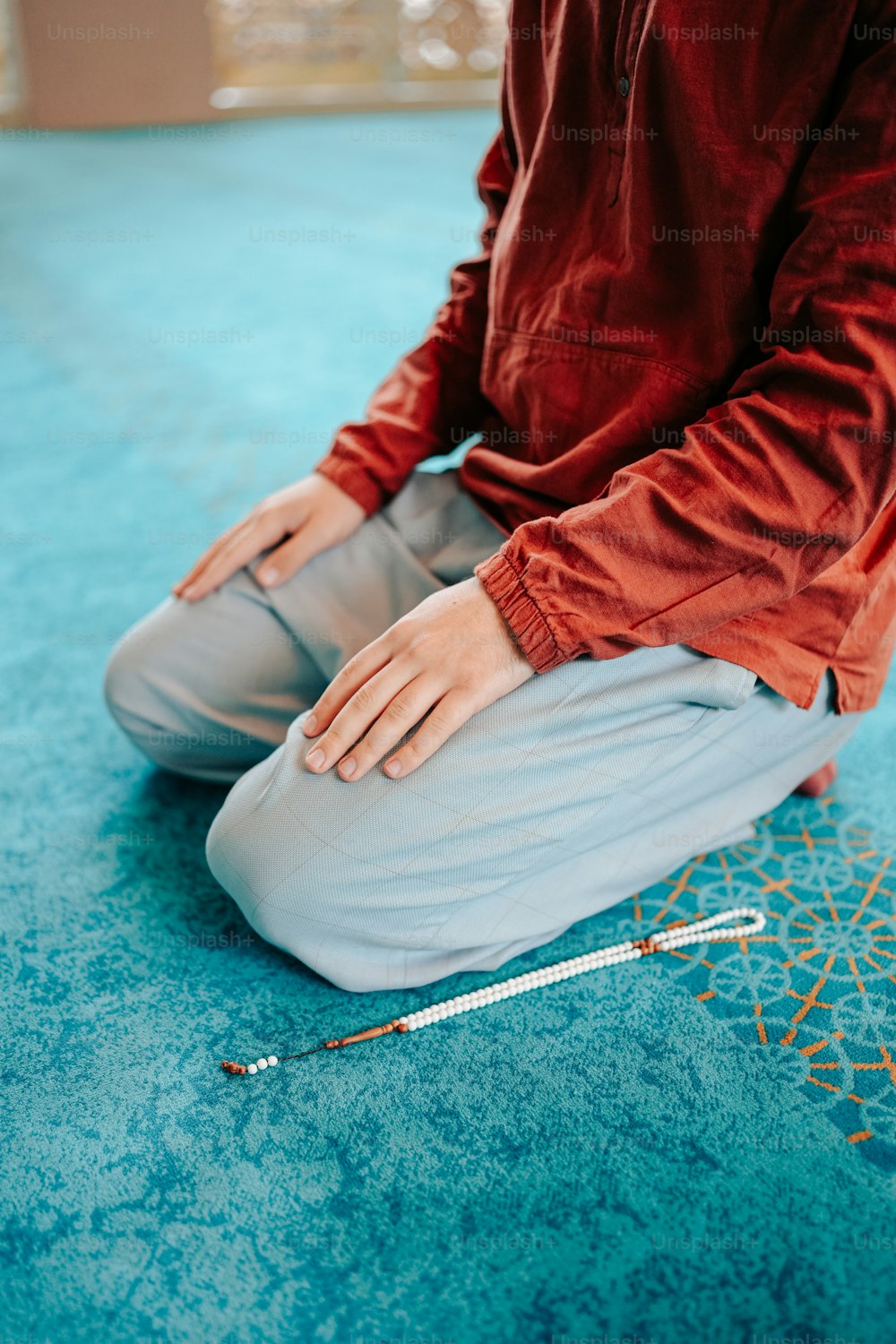 한 쌍의 뜨개질 바늘로 바닥에 앉아있는 사람