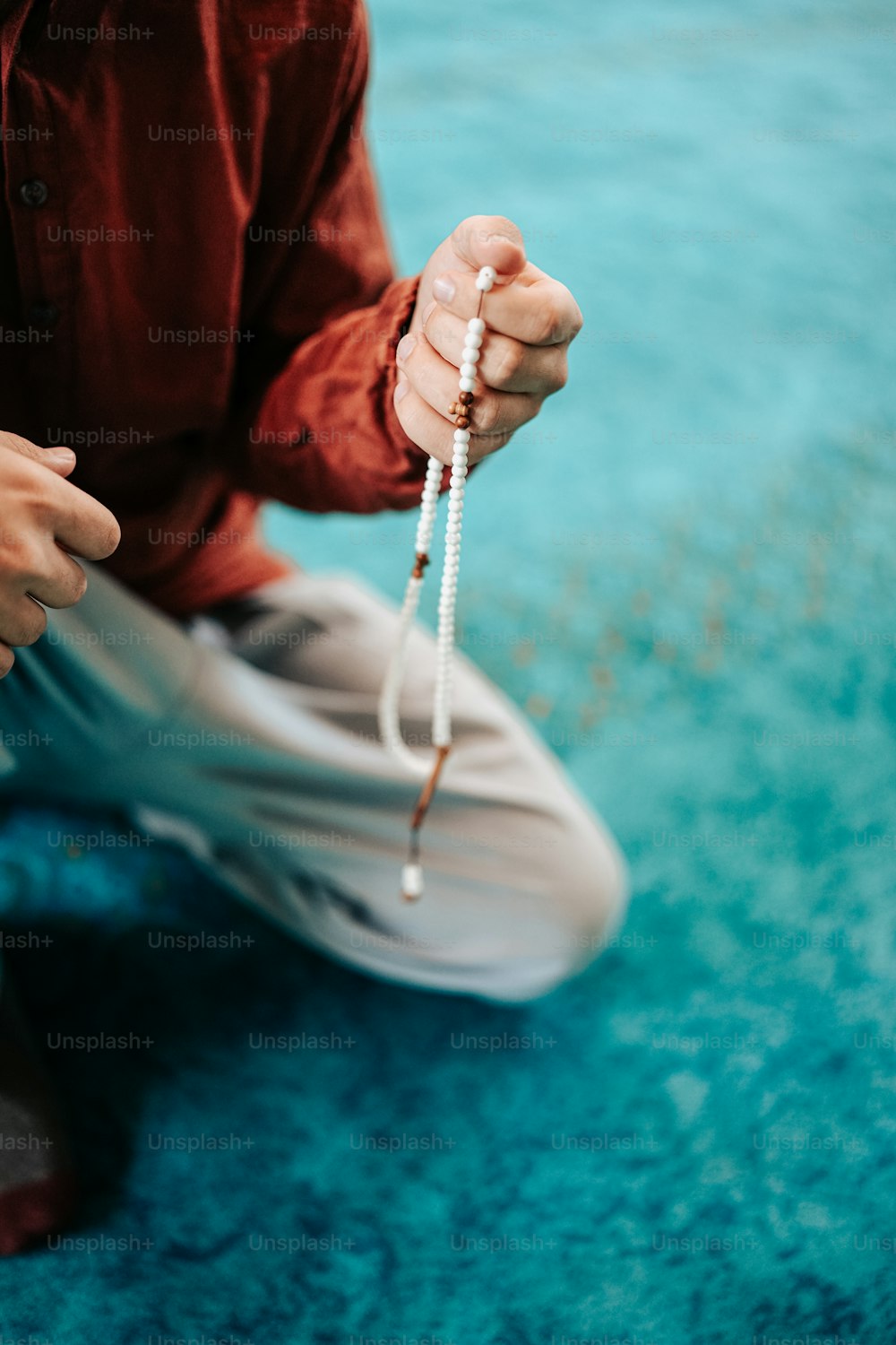 a person sitting on the ground holding a string