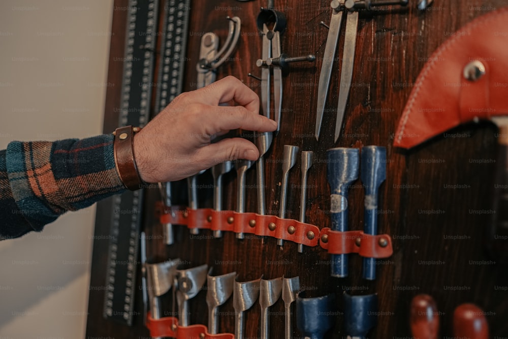 a man is holding a tool rack with a lot of tools on it