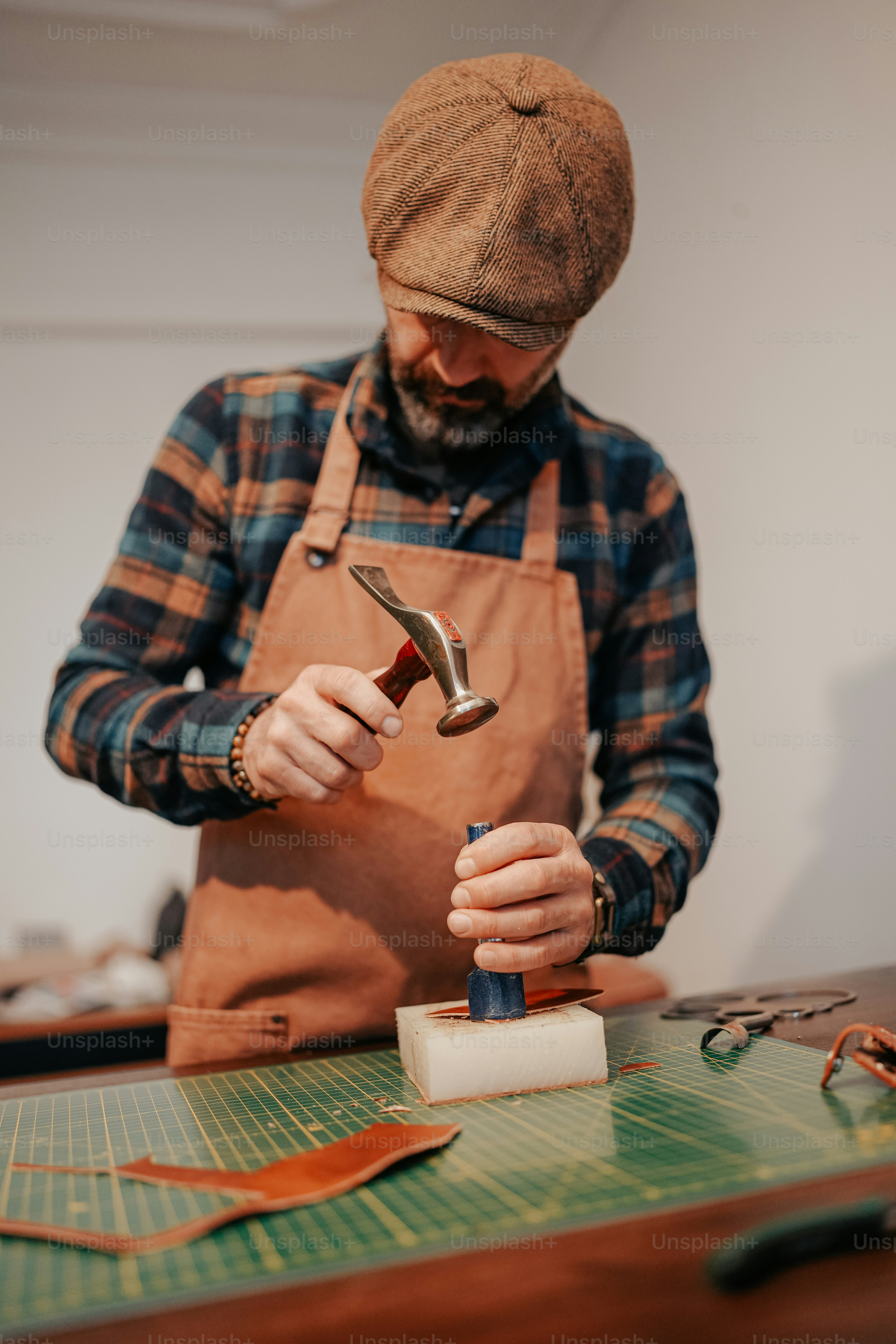 Ein Mann arbeitet mit einem Hammer auf einem Stück Holz