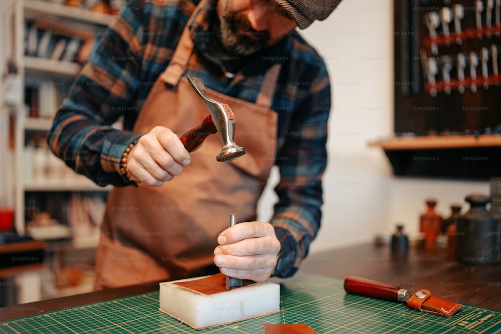 Ein Mann arbeitet mit einem Hammer an einem Stück Holz
