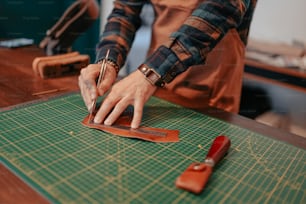 a person using a pair of scissors on a cutting mat