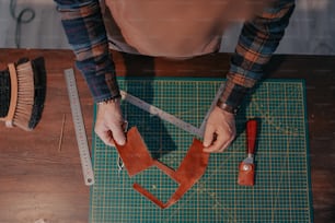 a person cutting a piece of leather with a pair of scissors