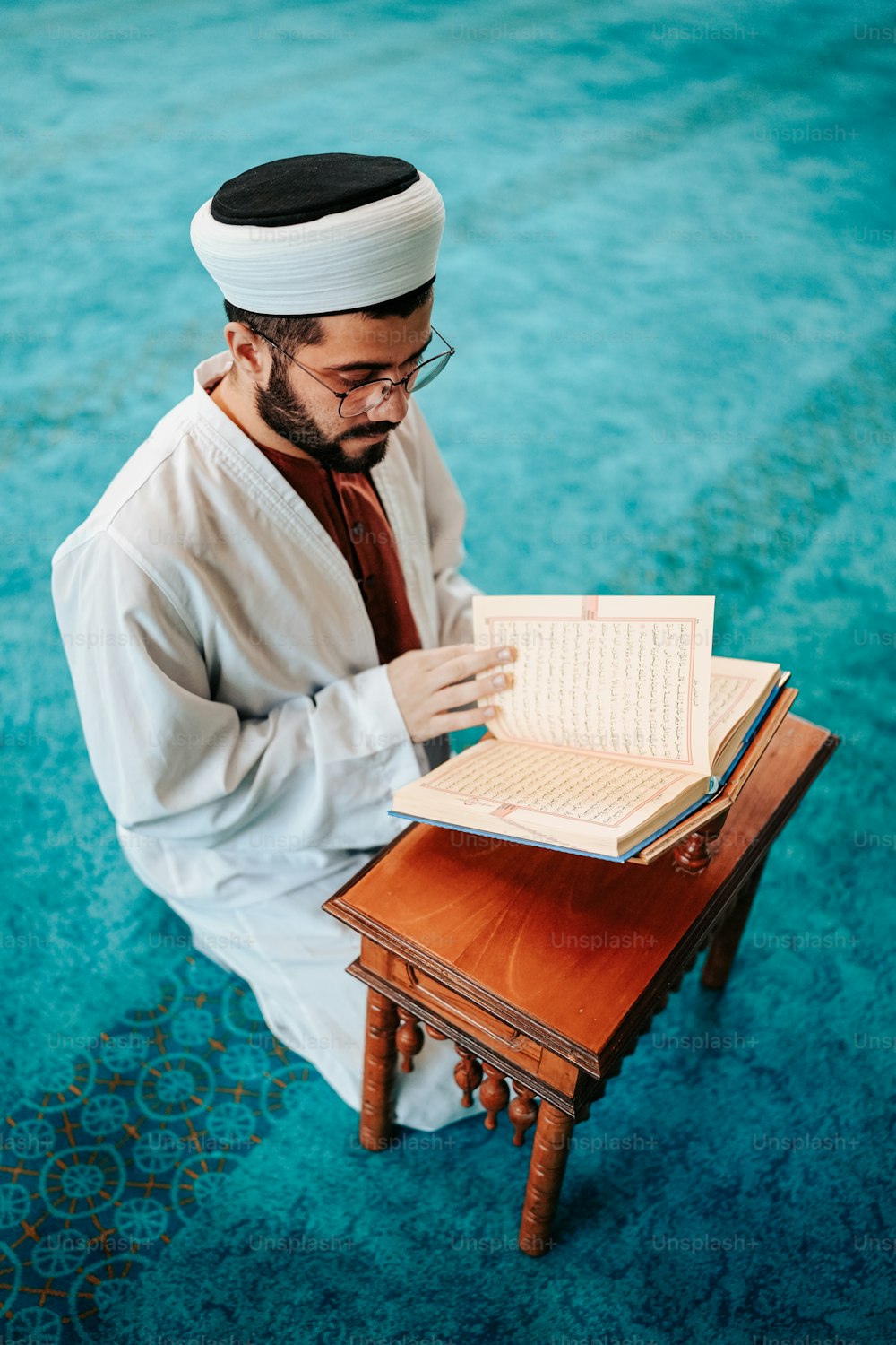 a man sitting on the floor reading a book