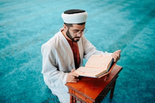 a man sitting at a desk with a book