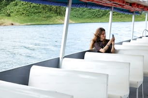 a woman taking a picture of herself on a boat