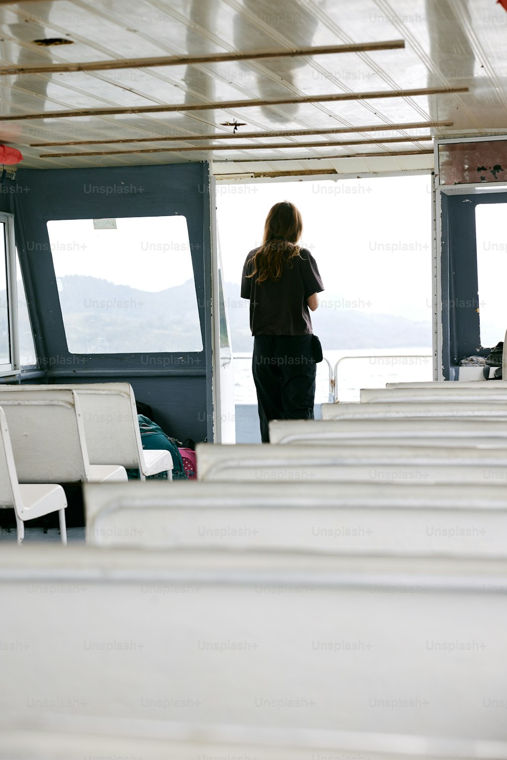 a woman standing on a boat looking out at the water