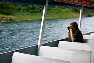 a woman taking a picture of a body of water