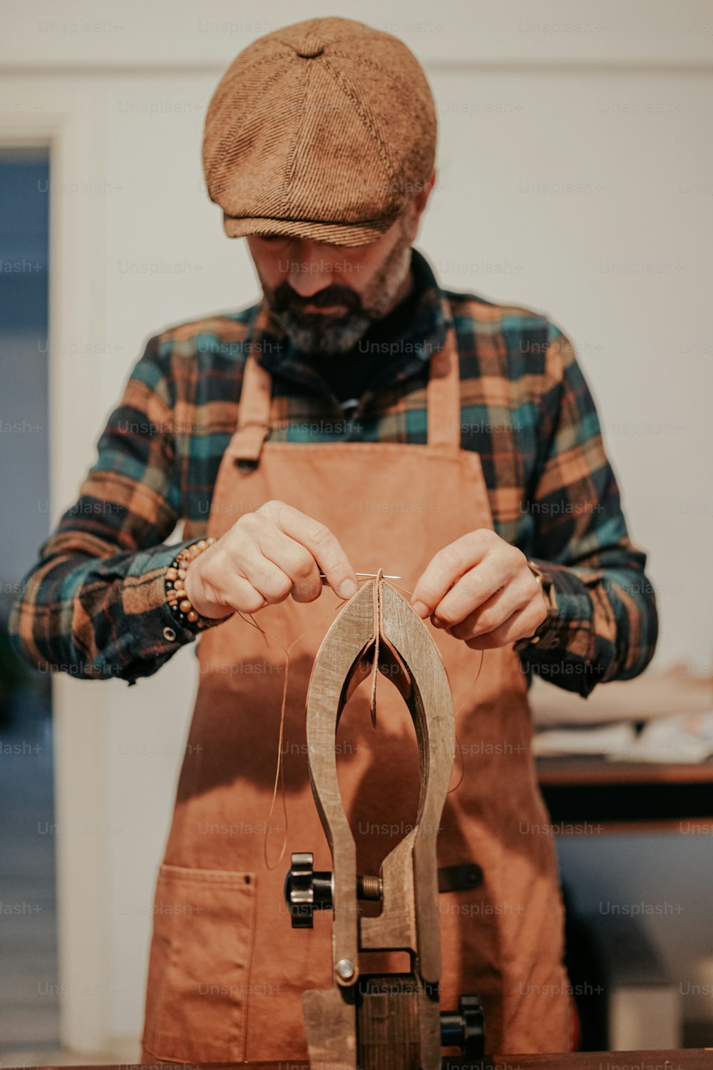 a man wearing an apron and a hat holding a pair of scissors