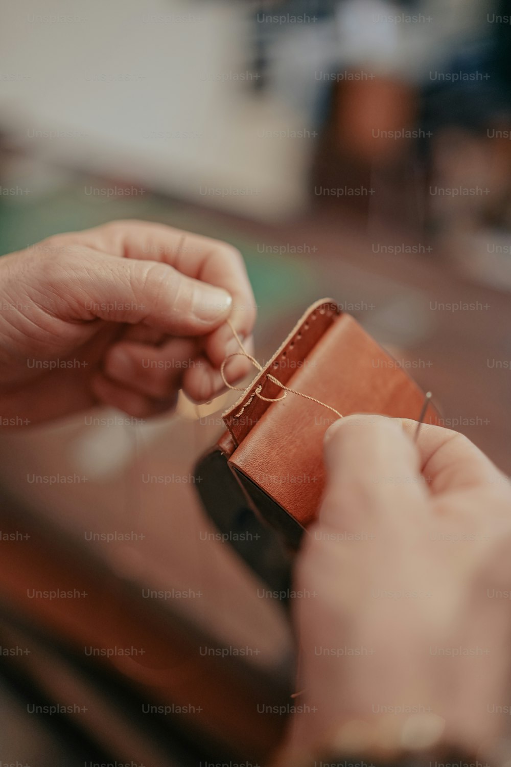 eine Person, die eine Brieftasche mit einer daran befestigten Schnur hält