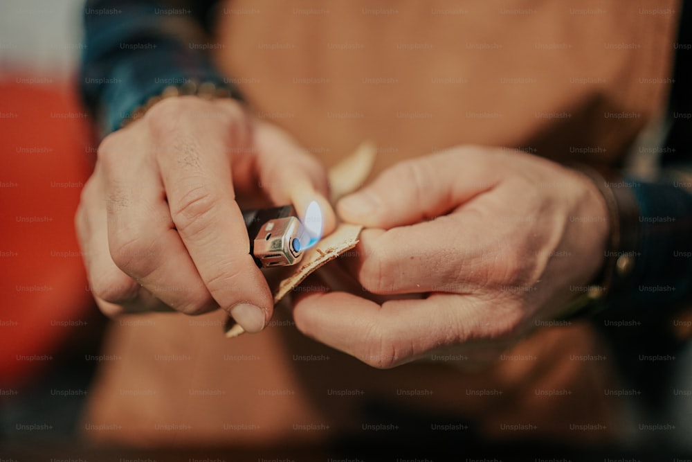 a person holding a lighter in their hands
