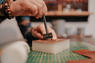 a person cutting a piece of cake with a knife