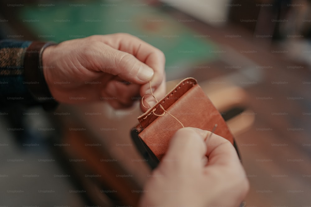 a person is holding a wallet and string