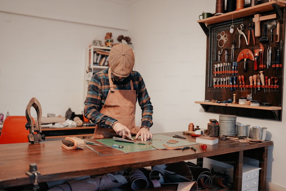 a man in a hat working on a piece of wood