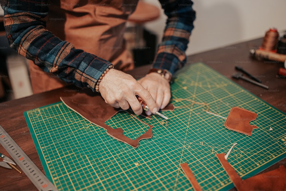 a person cutting leather with a pair of scissors