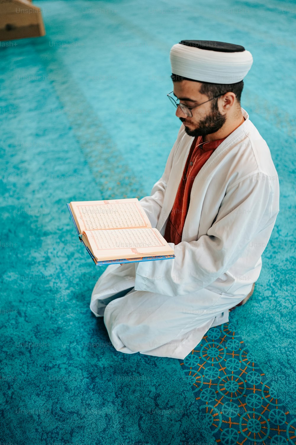 a man sitting on the floor reading a book