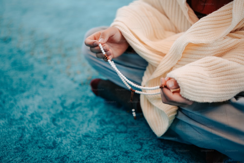 uma mulher sentada no chão segurando uma corda