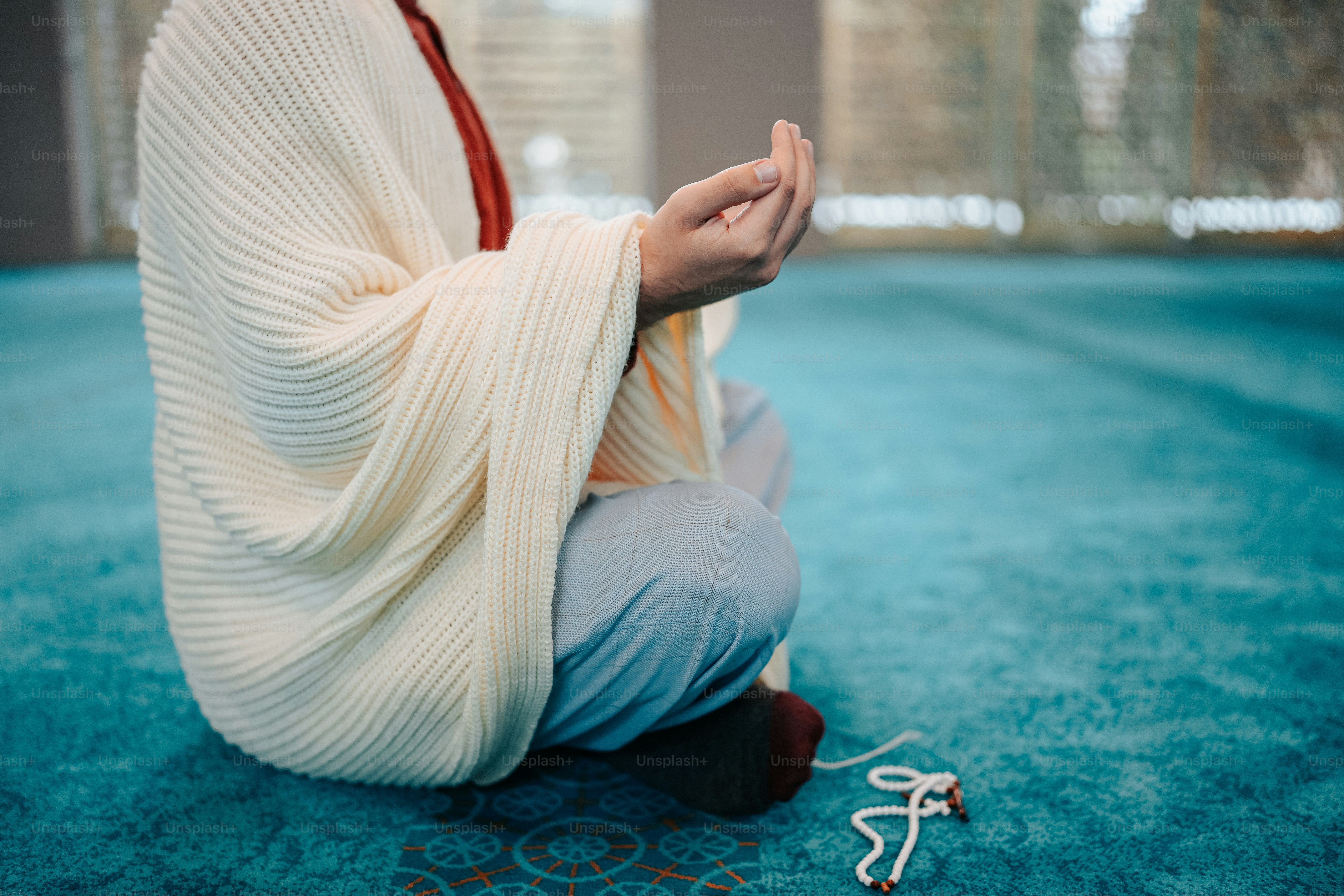a woman sitting on the floor holding her hands together