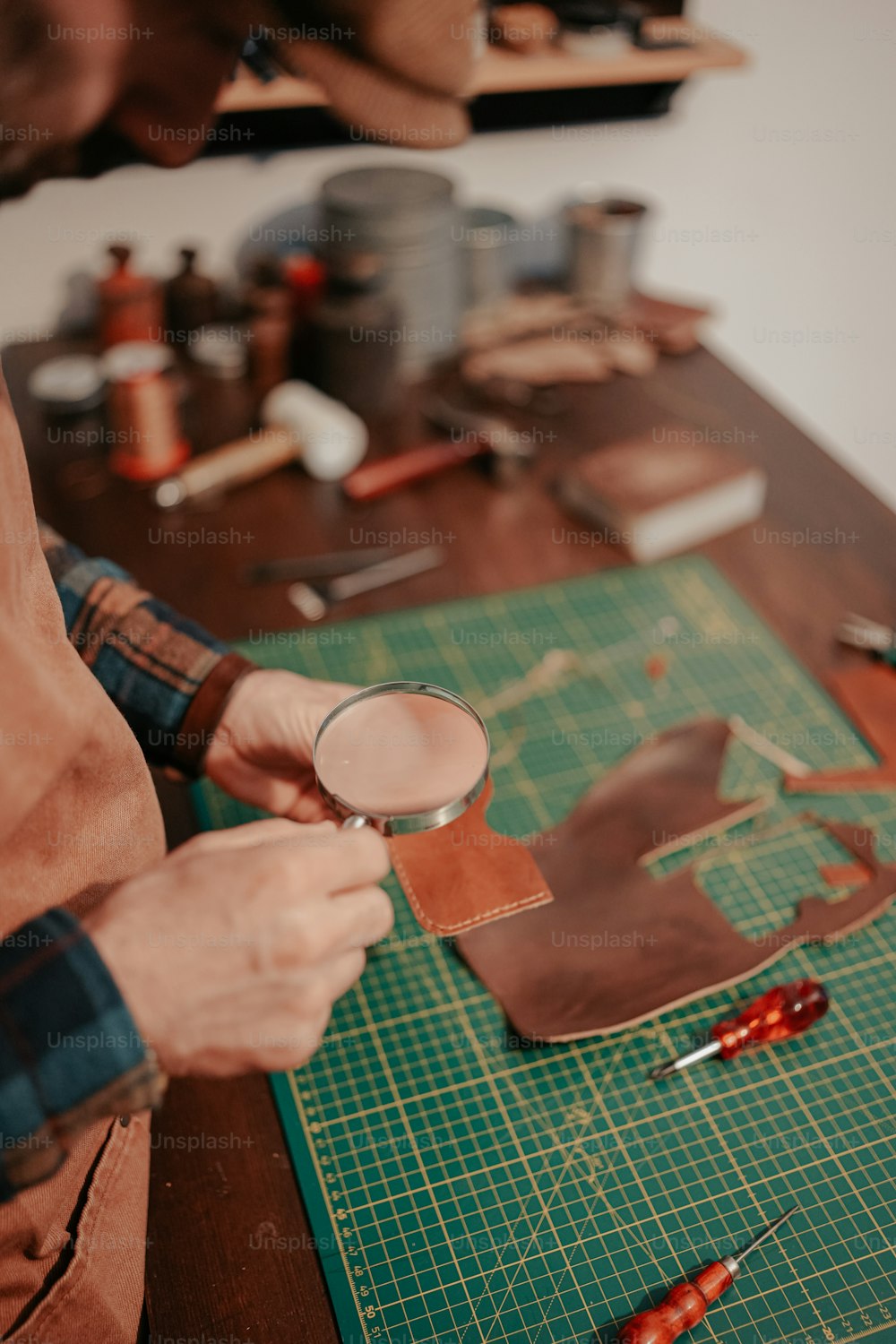 a man holding a magnifying glass on top of a cutting board