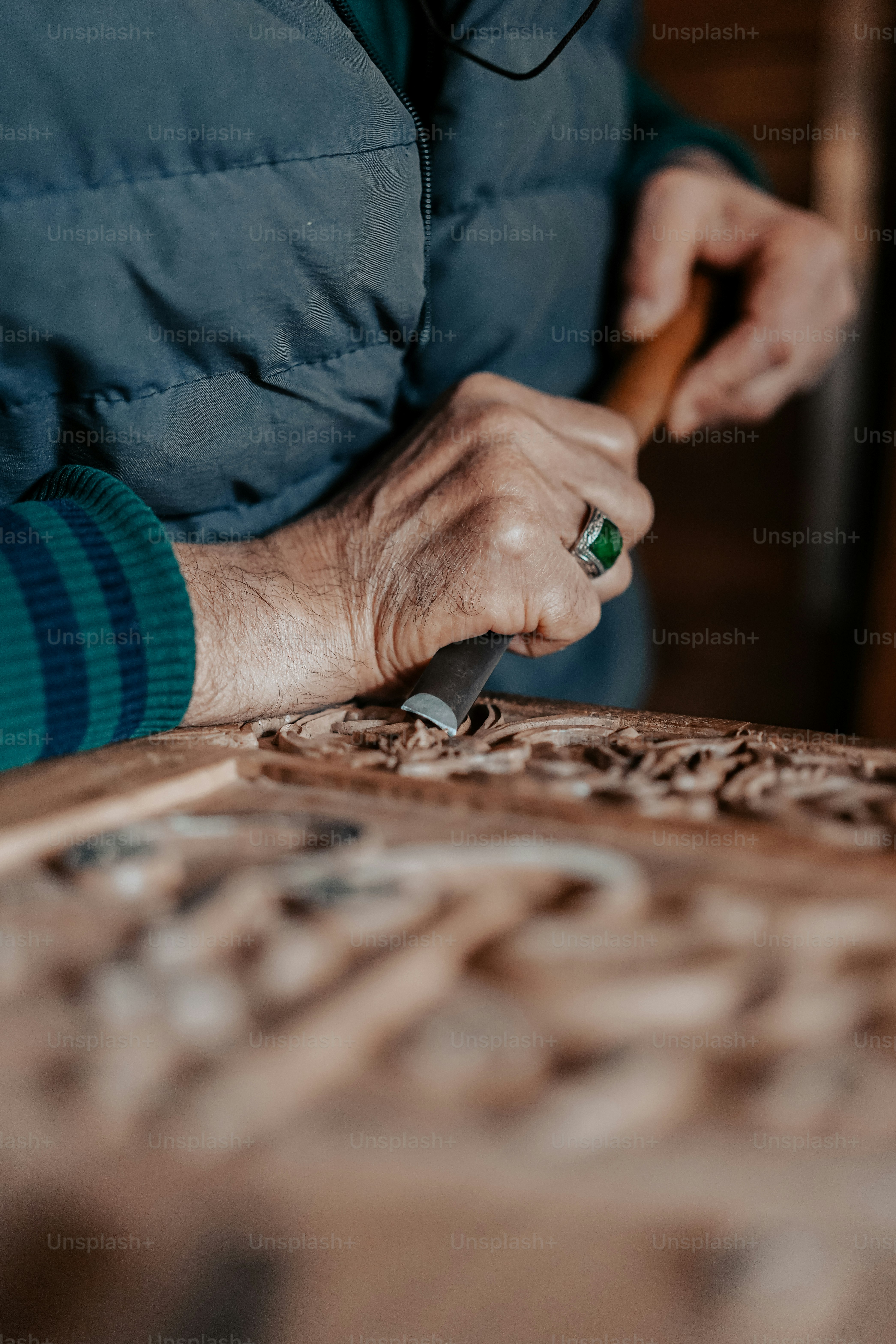 eine Person, die ein Holzschnitzwerkzeug auf einem Stück Holz benutzt