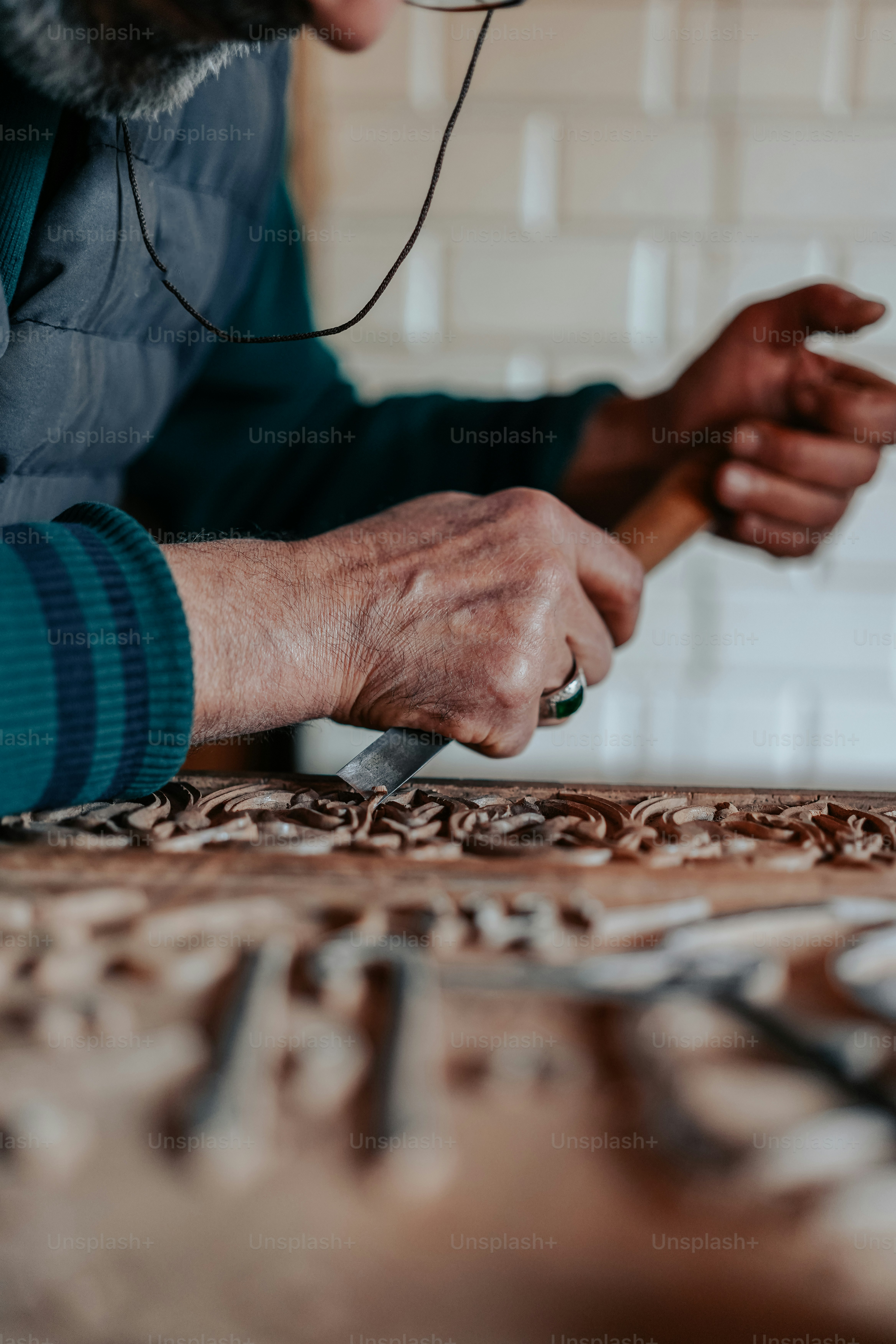 a man using a pair of scissors on a piece of wood