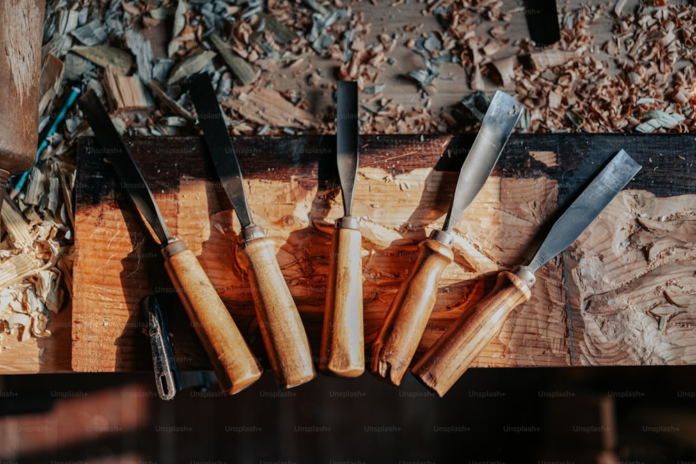 a group of knives sitting on top of a wooden table