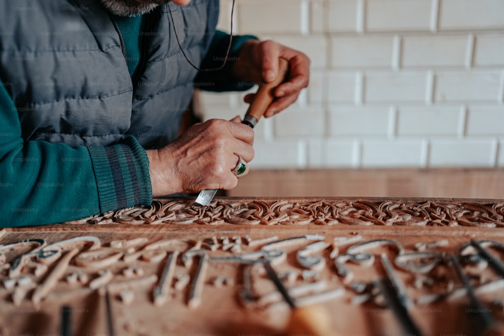 a man is carving a design on a piece of wood