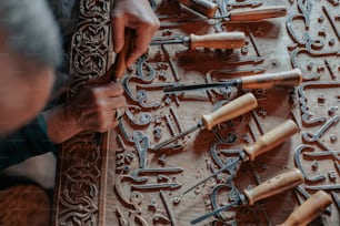 a man is working on a carving with many tools