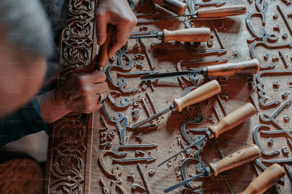 男は多くの道具で彫刻に取り組んでいます