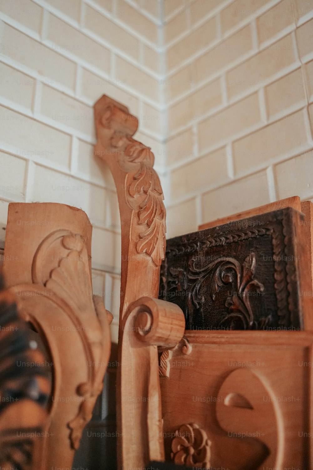 a close up of a wooden chair with a brick wall in the background