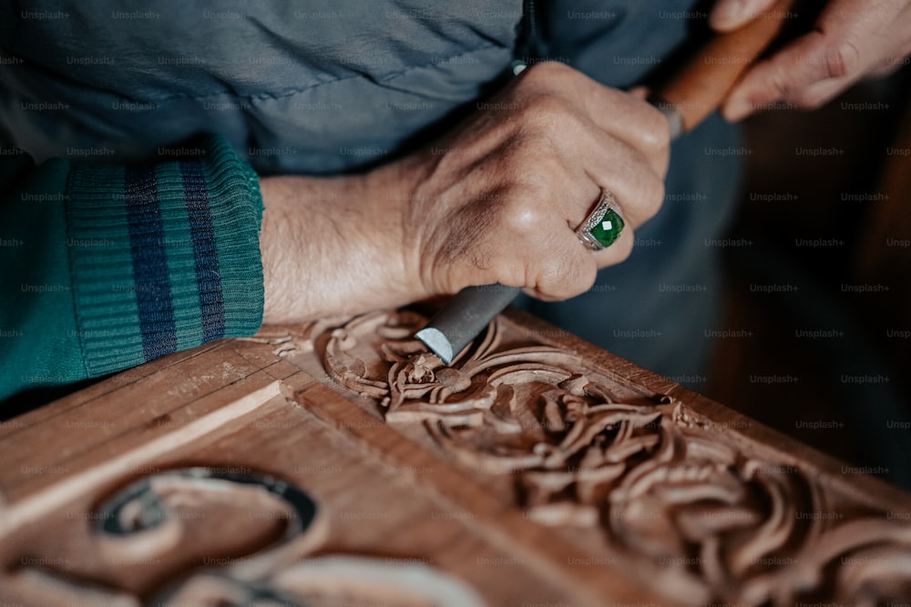 uma pessoa esculpindo um objeto de madeira com uma faca