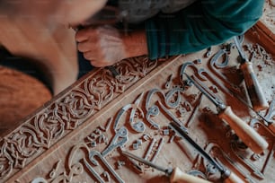 a man is working on a carving with tools