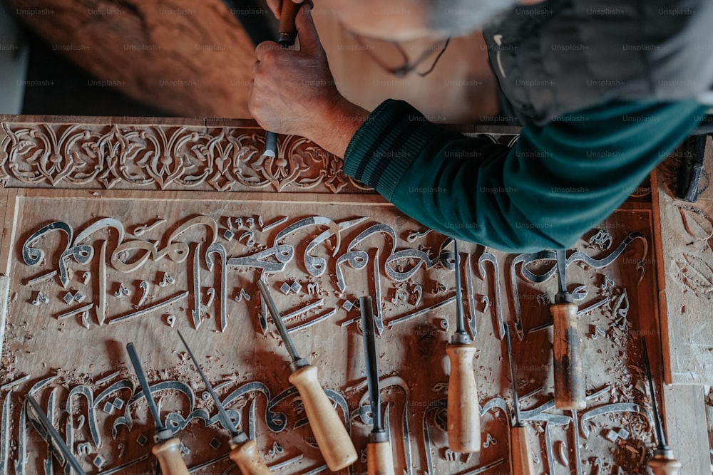 um homem trabalhando em uma escultura em uma parede