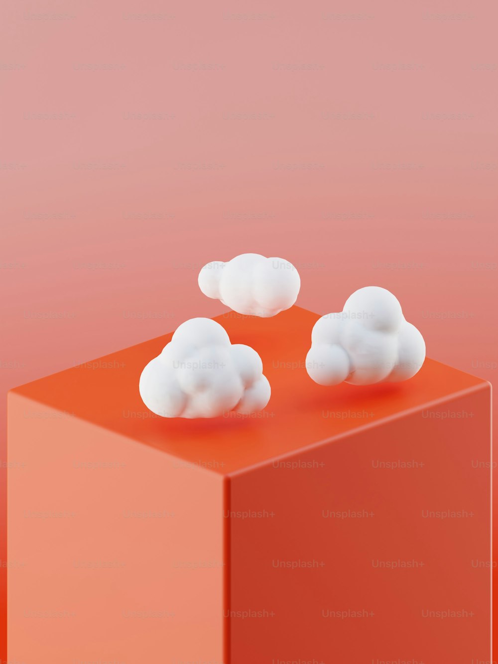 three white clouds on top of a red block
