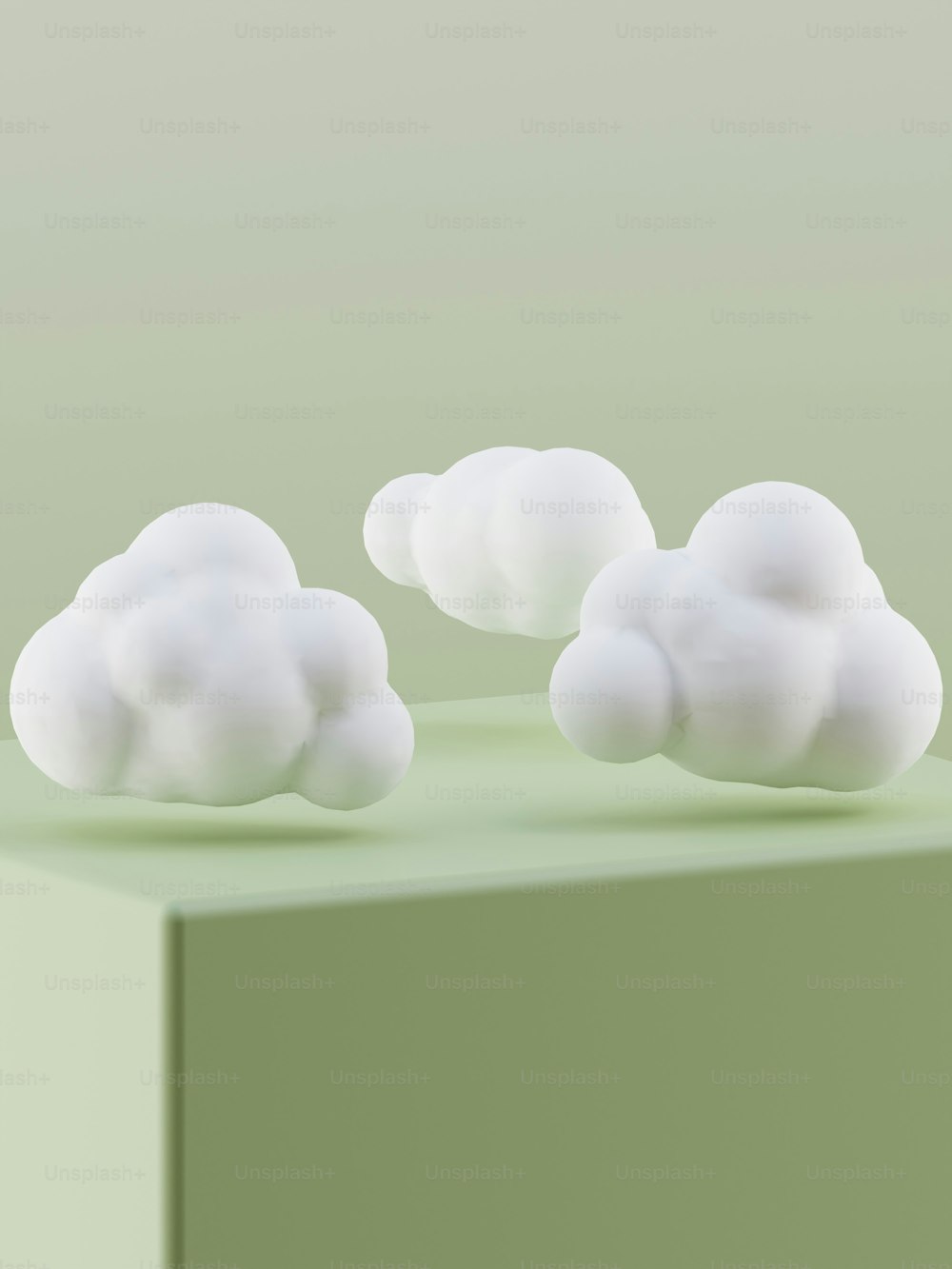 three white clouds sitting on top of a green table