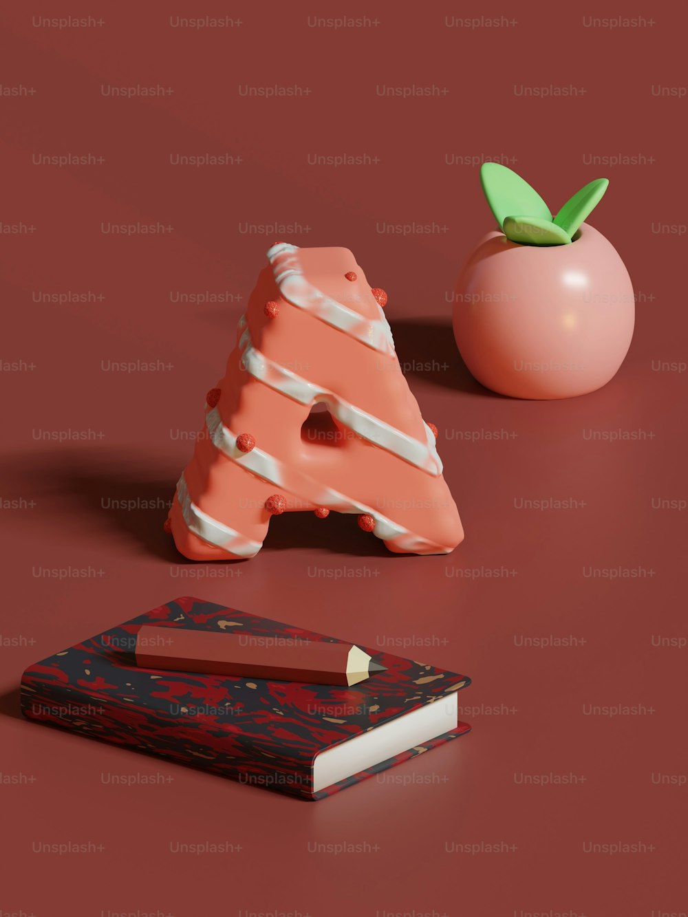 Un oggetto rosa seduto sopra un tavolo accanto a un libro