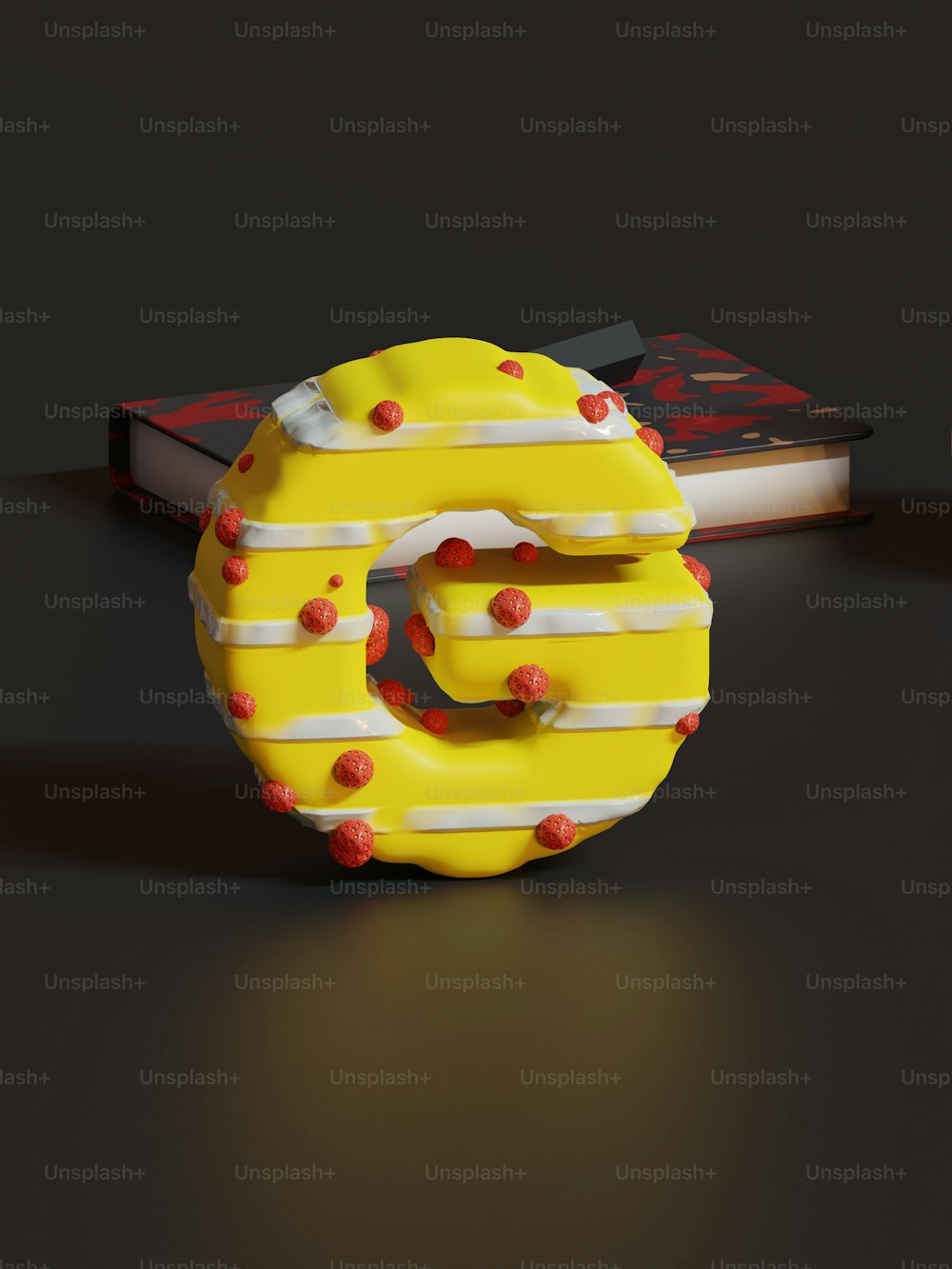 책 옆 테이블 위에 앉아 있는 노란 도넛