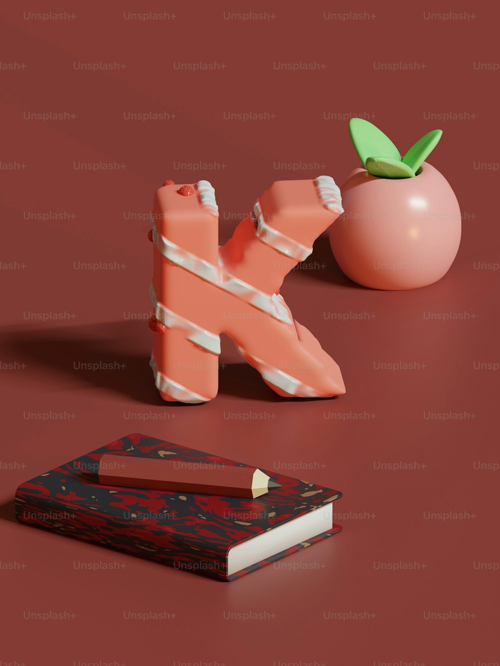 Ein Buch, ein Bleistifthalter und ein Apfel sitzen auf einer roten Fläche