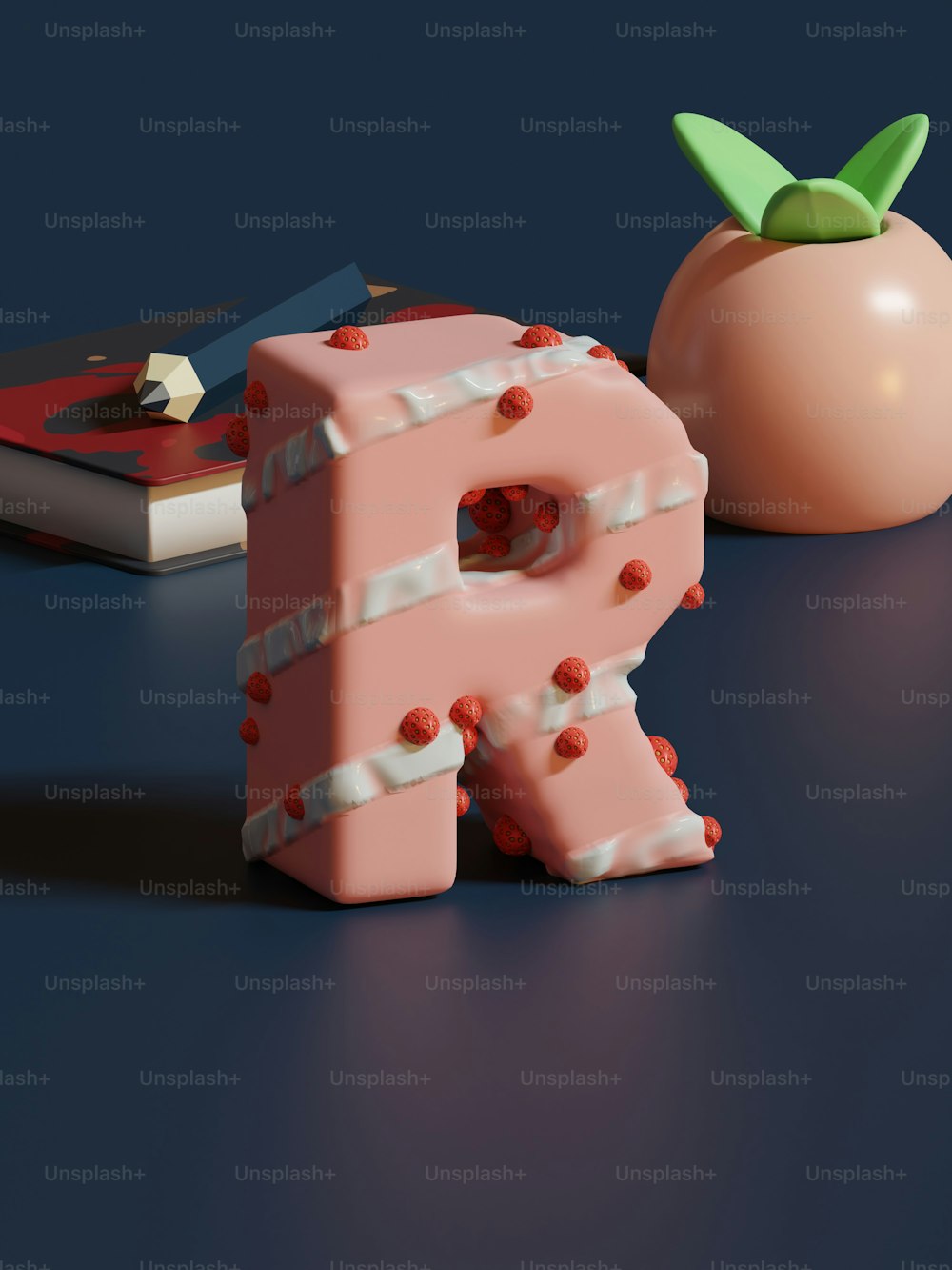 Un objeto rosa en forma de letra junto a un tomate