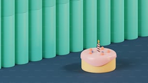 a birthday cake sitting in front of a row of green cylinders
