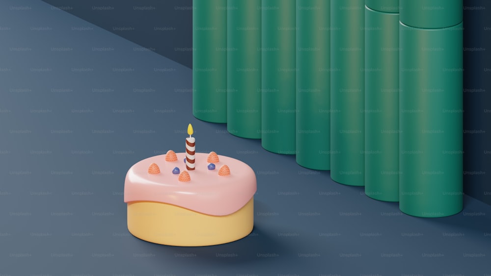 um bolo de aniversário sentado ao lado de uma fileira de cilindros verdes