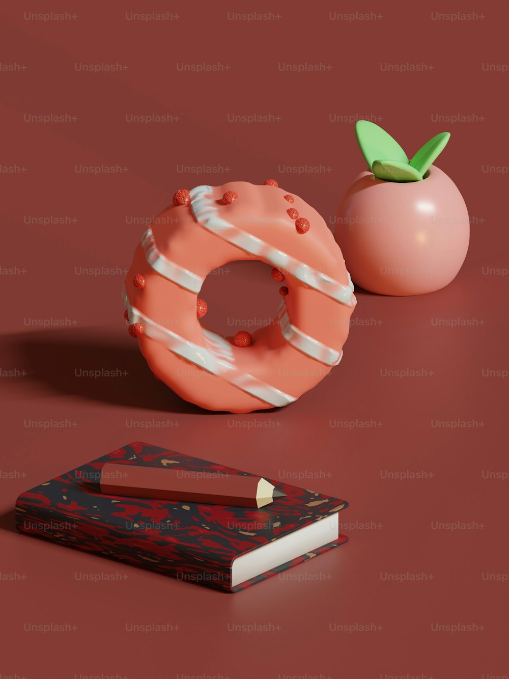 a donut and a book on a red surface