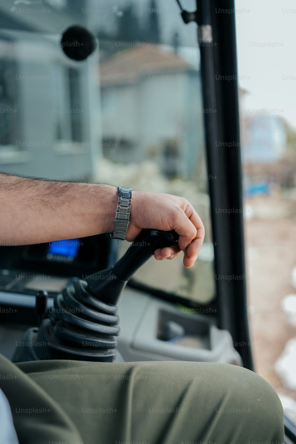 a man driving a bus with his hand on the steering wheel