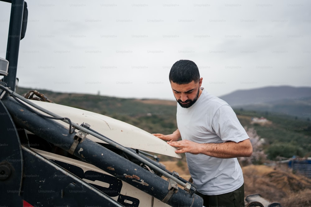 Un uomo in piedi accanto a un veicolo che tiene una tavola da surf