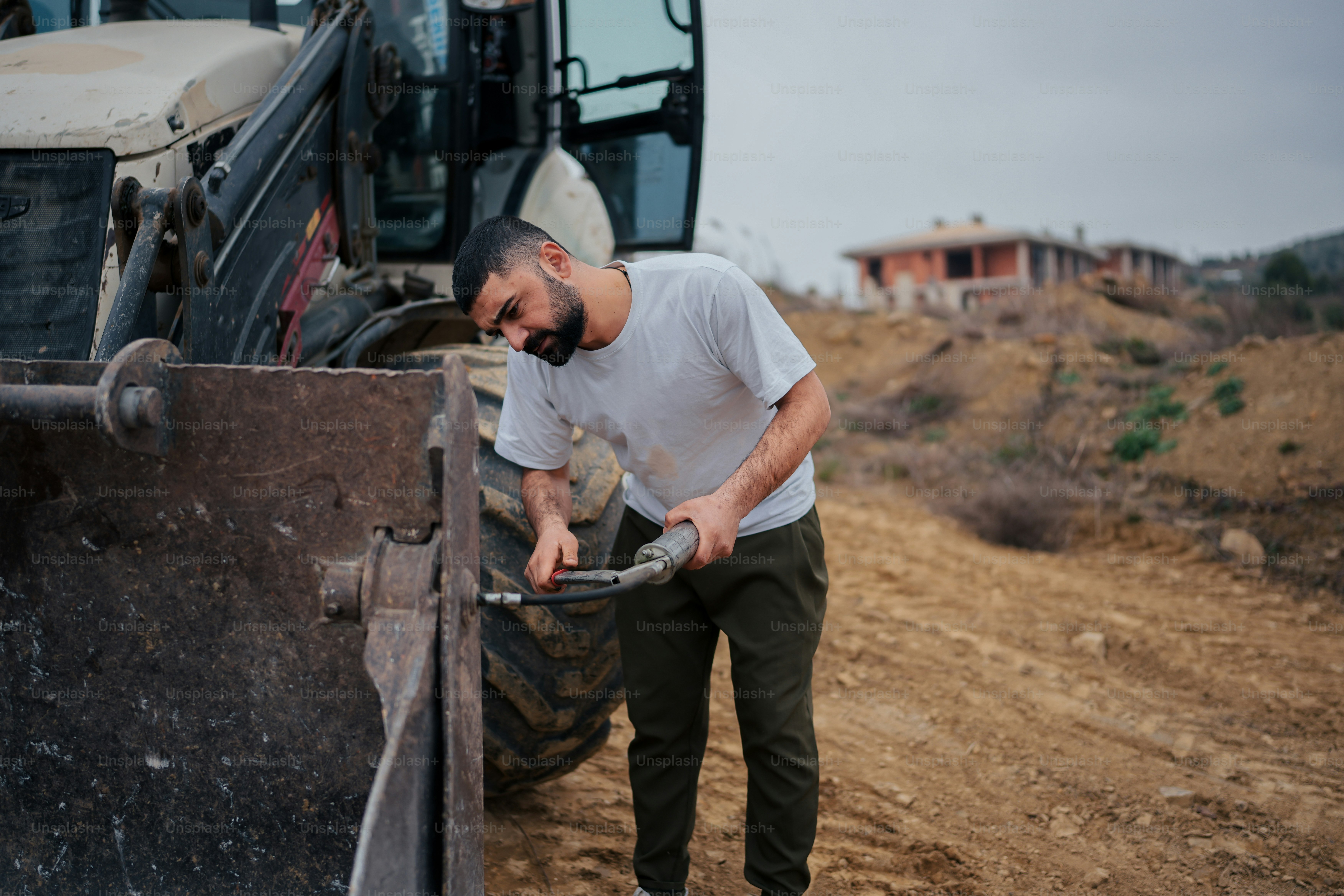 a man standing next to a tractor on a dirt road