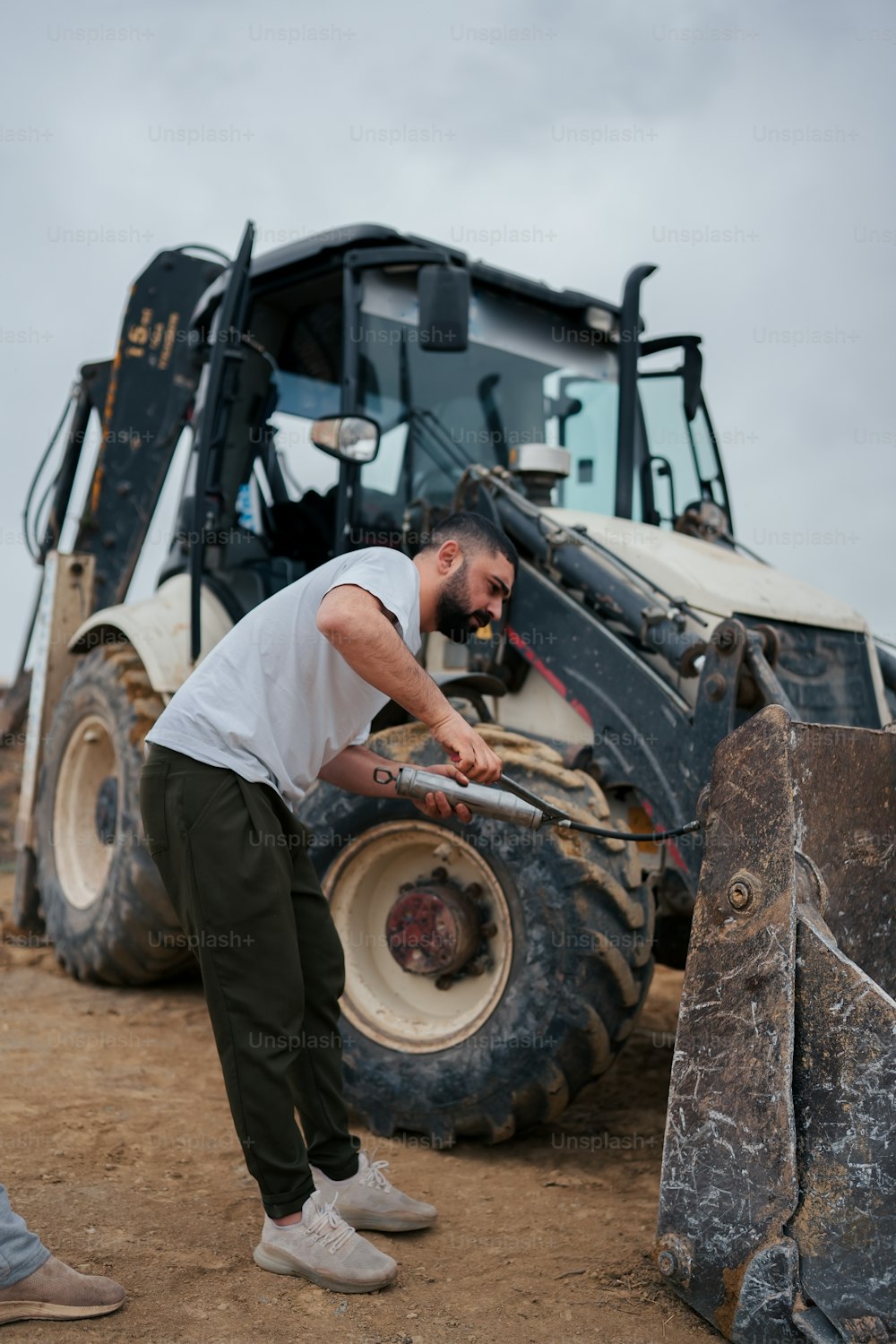 Un homme debout devant un bulldozer