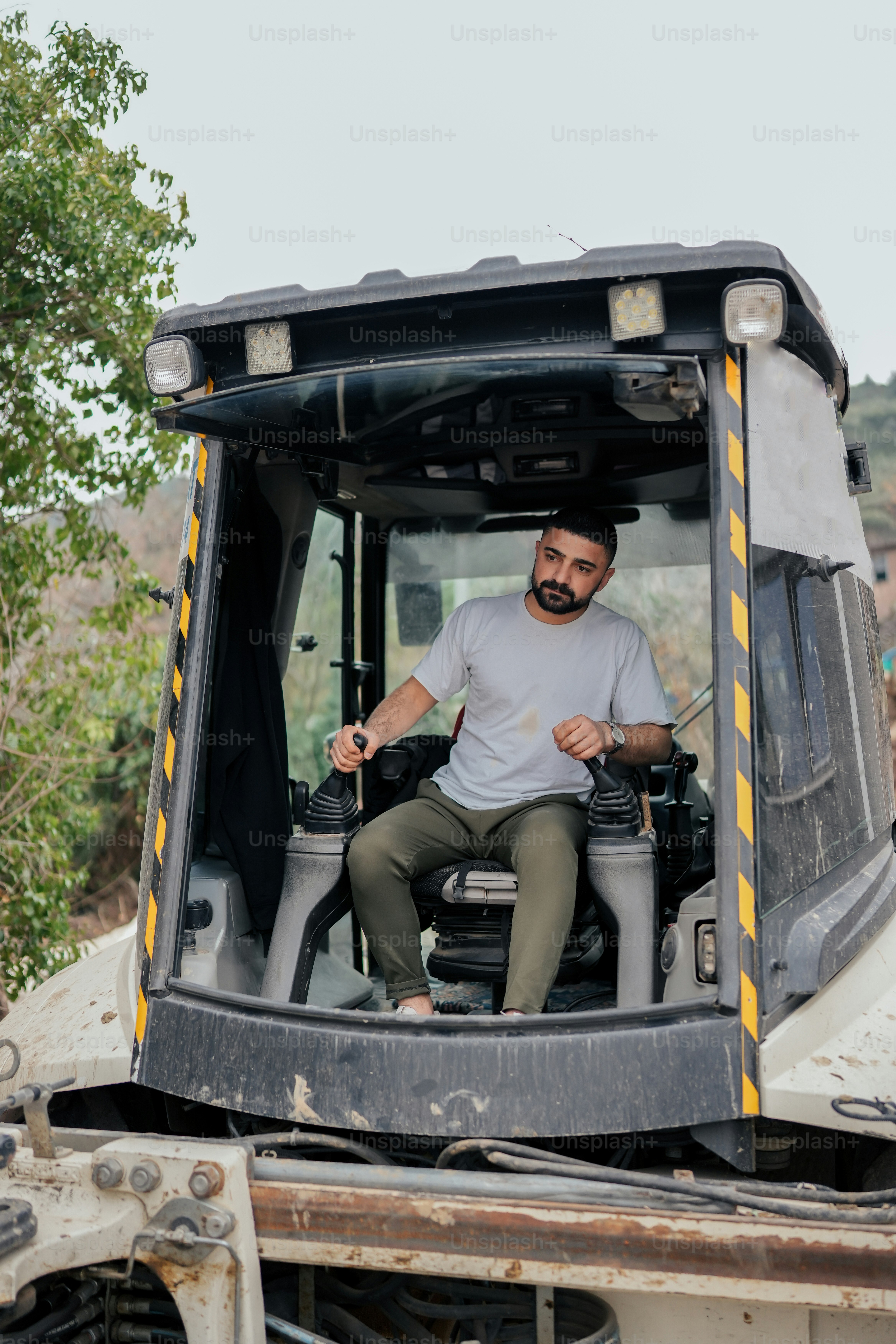 A man riding on the back of a construction vehicle photo – Digger Image ...