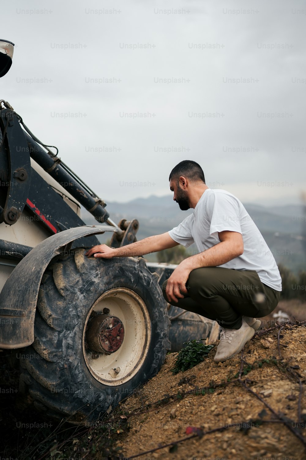 a man kneeling down next to a large truck